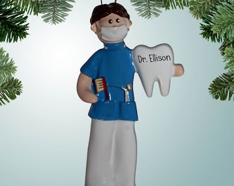 May include: A blue and white Christmas ornament depicting a dentist holding a large white tooth with the name "Dr. Ellison" written on it.