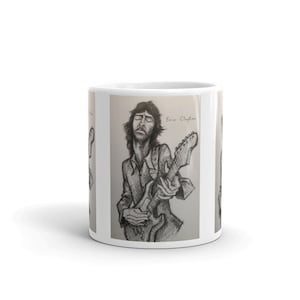 May include: A black and white pencil drawing of Eric Clapton playing a guitar. The drawing is on a white background with the text "Eric Clapton" written in black.
