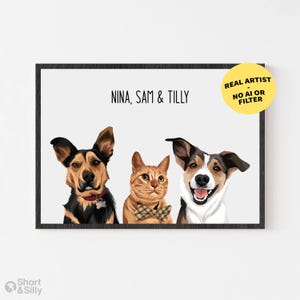 Op de afbeelding: Een ingelijste digitale illustratie met portretten van twee honden en een kat met de tekst NINA, SAM & TILLY. De linkerhond is zwart en bruin met een rode halsband, de middelste kat is oranje met een geruite vlinderdas, de rechterhond is bruin en wit.