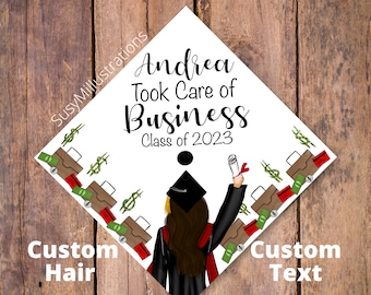 May include: A graduation cap with a white background and a black and white illustration of a woman in a graduation cap and gown. The text "Andrea Took Care of Business Class of 2023" is printed on the cap. The cap is decorated with images of money and briefcases.