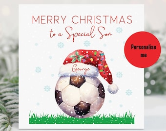 May include: A white and black soccer ball wearing a red Santa hat with a green holly sprig and Christmas lights. The hat has the name "George" written on it. The background is white with a snowy effect and the text "Merry Christmas to a Special Son".