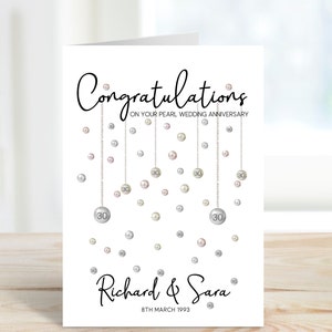 Congratulations on your pearl wedding anniversary. Beautiful hanging pearls and personalised with the couples name and date.