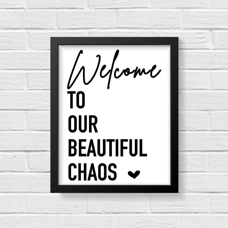 May include: Black and white framed print with the text "Welcome to our beautiful chaos" and a small heart symbol.