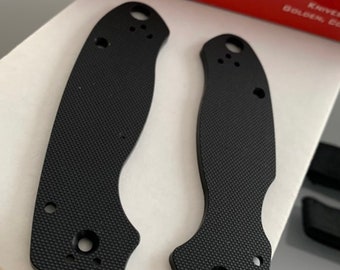 May include: Two black, textured, knife scales with rounded edges and multiple holes. The scales are made for a Spyderco knife.
