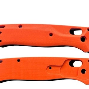 Puede incluir: Dos escamas de cuchillo de plástico naranja con detalles negros. Las escamas tienen una superficie texturizada y están diseñadas para adaptarse a un mango de cuchillo.