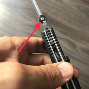May include: A black and silver pocket knife with a partially open blade. The knife has a textured black handle and a silver blade with a black pivot screw.