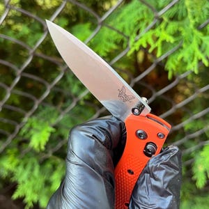 Könnte beinhalten: Ein rot-schwarzes Taschenmesser mit einer teilweise geöffneten Klinge. Die Klinge hat ein Schmetterlingslogo.