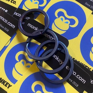 May include: Four dark blue key rings are arranged on a background of yellow and blue business cards. The cards feature a monkey logo and the text "monkey" and "nenco.com Since 2018".
