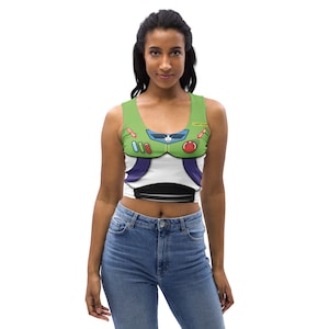 May include: A green, white, and purple crop top featuring a Buzz Lightyear costume design. The top has a scoop neck and a sleeveless design. The front of the top has the words "TRY ME" and "LIGHTYEAR".