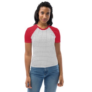 Può includere: Una maglietta a fantasia a griglia rossa e bianca. La maglietta ha maniche rosse e un corpo bianco con un motivo a griglia nera. La maglietta è realizzata in un materiale morbido e confortevole.