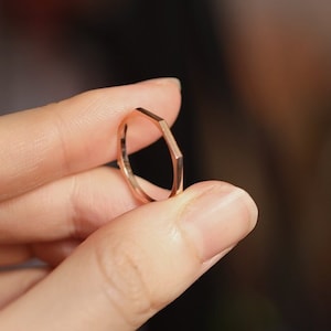 May include: A rose gold hexagonal ring.