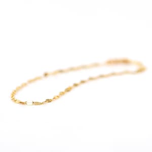 Puede incluir: Un delicado collar de cadena de oro con peque&ntilde;os eslabones ovalados planos.