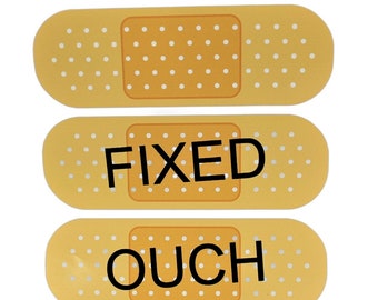 May include: Three yellow band-aid style stickers with the words "FIXED", "OUCH" printed on them.