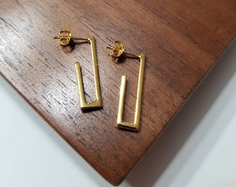 May include: A pair of gold-toned rectangle shaped earrings with a simple design.