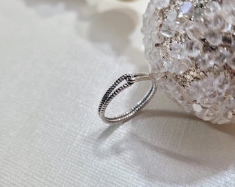 May include: A silver ring with a twisted rope design.