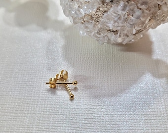 May include: A pair of gold stud earrings with small round balls at the ends.