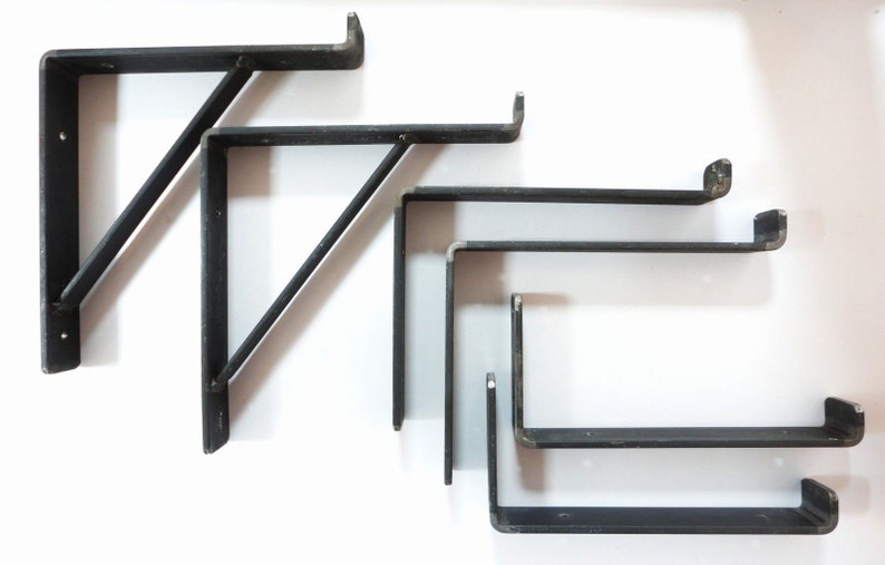 May include: Set of five black metal shelf brackets. Two brackets are angled and three are straight. The brackets are all different sizes.