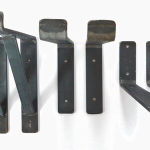 May include: Set of six black metal shelf brackets. Two brackets are angled and four are L-shaped.