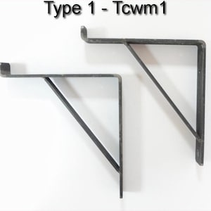 May include: Two black metal shelf brackets, each with a triangular support, are shown against a white background. The brackets are labeled "Type 1 - Tcwm1".