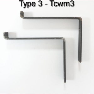 May include: Two black metal shelf brackets, one larger than the other, are shown against a white background. The brackets are L-shaped and have a slight curve at the top.