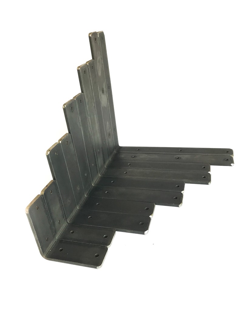K&ouml;nnte beinhalten: Ein Stapel schwarzer Metalleckwinkel, die in Dreiecksform angeordnet sind. Die Winkel sind aus robustem Metall gefertigt und haben mehrere L&ouml;cher zum Befestigen an Holz oder anderen Materialien.