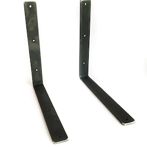 K&ouml;nnte beinhalten: Zwei schwarze Metall-Regalb&ouml;cke mit jeweils vier L&ouml;chern. Die B&ouml;cke sind L-f&ouml;rmig und haben eine leicht abgerundete Kante.