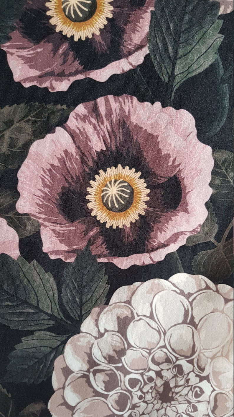 May include: A floral print fabric with large pink and white flowers on a black background. The flowers have a dark center with a yellow ring around it.