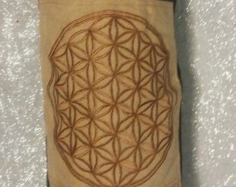 May include: A brown and beige yoga mat with a brown flower of life design. The mat has a zippered pocket.