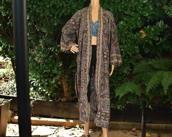 May include: A long, black and brown paisley patterned kimono with a long sleeve. The kimono is open in the front and has a belt.