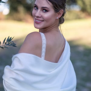 Ivory soft wedding shawl on a bride standing three quarters to the camera