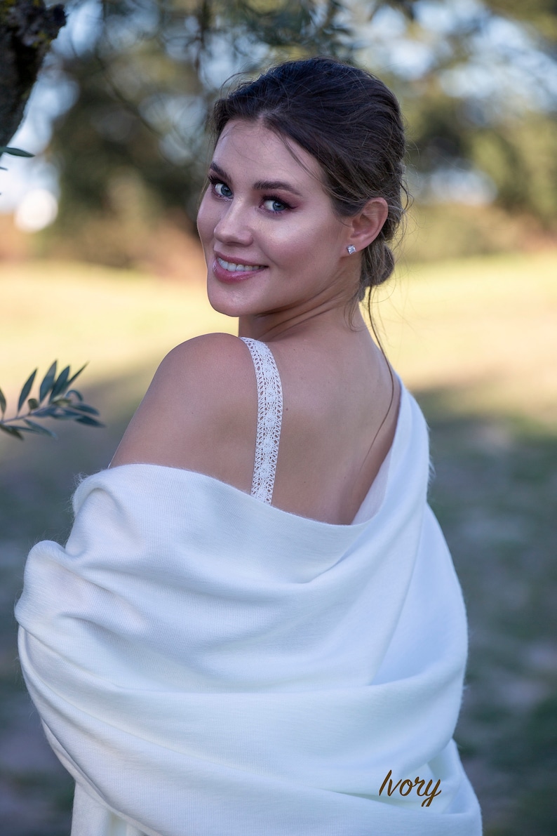 Ivory soft wedding shawl on a bride standing three quarters to the camera