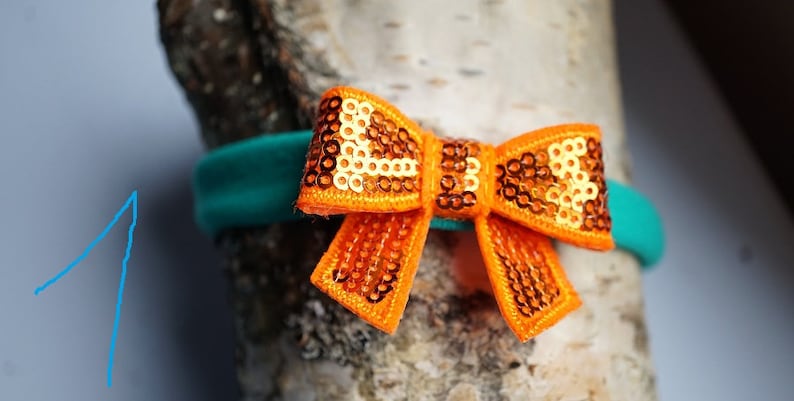 Pretty elastic hairband with glittering sequin bow.