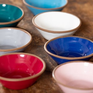 Peut inclure: Un ensemble de six petits bols de différentes couleurs, dont turquoise, blanc, gris, bleu, rouge et rose. Les bols sont tous en céramique et ont une forme légèrement arrondie.