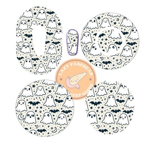May include: Four round adhesive patches with a white background and a black and white pattern of ghosts, bats, stars, and crescent moons. The patches are designed for use on medical devices. A smaller patch with a purple background and a white ghost design is also included.