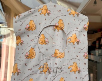 Könnte beinhalten: Eine hellblaue Wäscheklammer-Tasche mit einem sich wiederholenden Muster eines Cartoon-Bären und -Schweins. Die Tasche hat eine kreisförmige Öffnung und das Wort "Pegs" in Schreibschrift gestickt. Der Satz "Most Special Sort of Friends" ist ebenfalls aufgedruckt.
