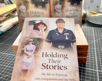 Könnte beinhalten: Mehrere Exemplare des Buches "Holding Their Stories" von Jennie Negus. Das Cover zeigt eine Frau in Krankenschwesteruniform und Vintage-Fotos. Der Untertitel des Buches lautet "My life in Nursing; care, compassion and the NHS."