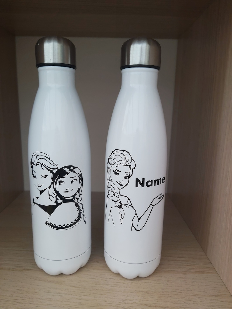 May include: Two white stainless steel water bottles with black and white images of Disney's Frozen characters. One bottle features Elsa and the other features Anna and Elsa. The bottle with Elsa has the word "Name" printed on it.