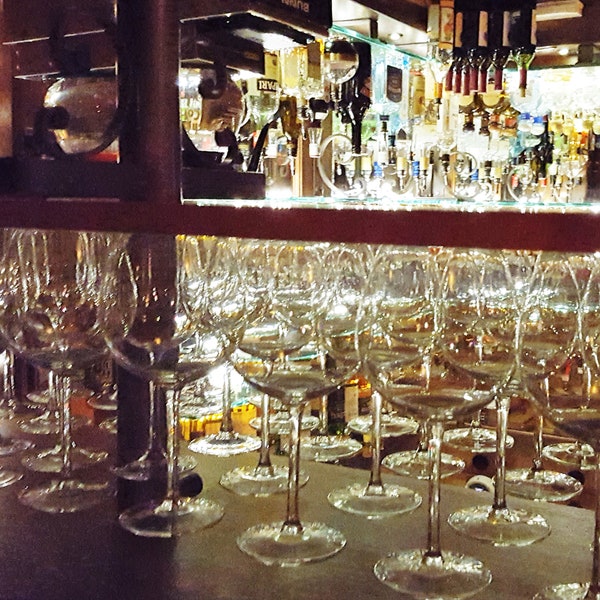 Digital photo of long stem bar glasses and other glassware in cabinet setup