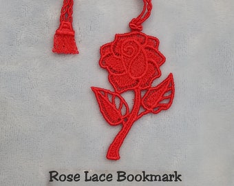 May include: Red lace bookmark shaped like a rose with a tassel. The bookmark has the text "Rose Lace Bookmark 1184 Scarlet Rose" on a white label.