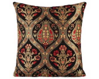 May include: A black cushion with a gold, red and cream floral pattern. The cushion is square shaped and has a soft, plush texture.