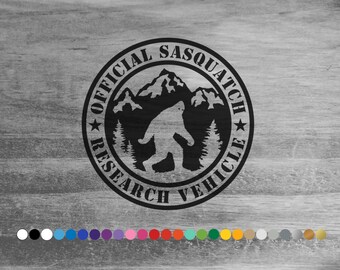 May include: Black and white sticker with the text "Official Sasquatch Research Vehicle" in a circle with a silhouette of Bigfoot walking in front of a mountain range.