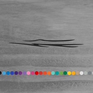 May include: A black vinyl decal featuring a sleek, elongated, and abstract tribal-style graphic design. Below the graphic, a horizontal row of twenty-five small, circular color swatches is displayed, showcasing various available color options.