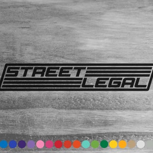 May include: Black and white sticker with the text "STREET LEGAL" in a retro font style. The sticker has a black border and multiple black stripes.