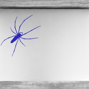 May include: A blue spider silhouette sticker on a white laptop.