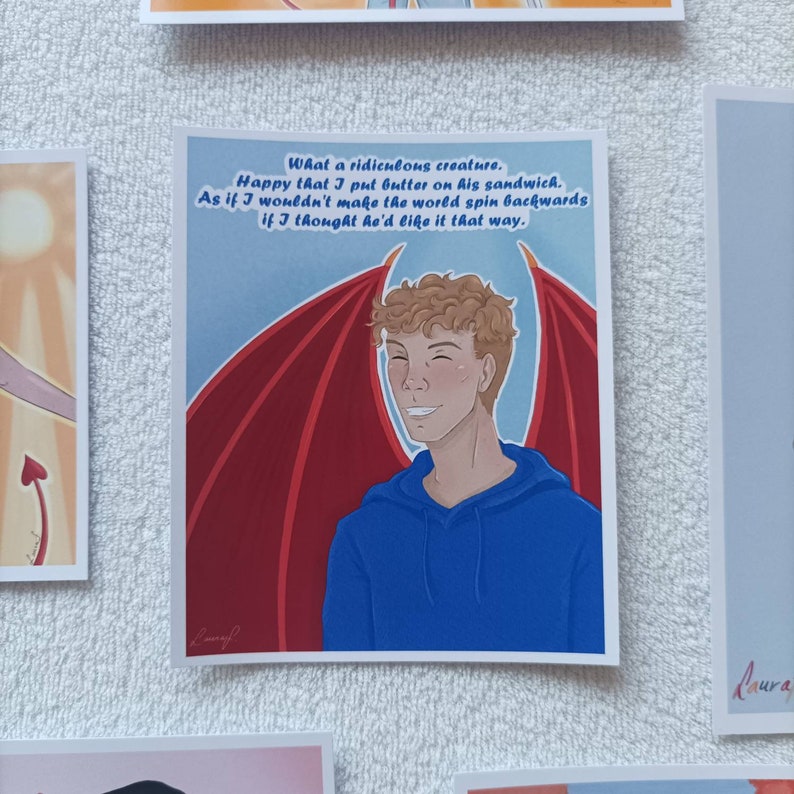 Puede incluir: Una tarjeta ilustrada roja y azul con una persona joven con cabello casta&ntilde;o rizado y alas rojas. El texto en la tarjeta dice "Qu&eacute; criatura tan rid&iacute;cula. Feliz de que le pusiera mantequilla en su s&aacute;ndwich. Como si no hiciera girar el mundo al rev&eacute;s si pensara que le gustar&iacute;a."