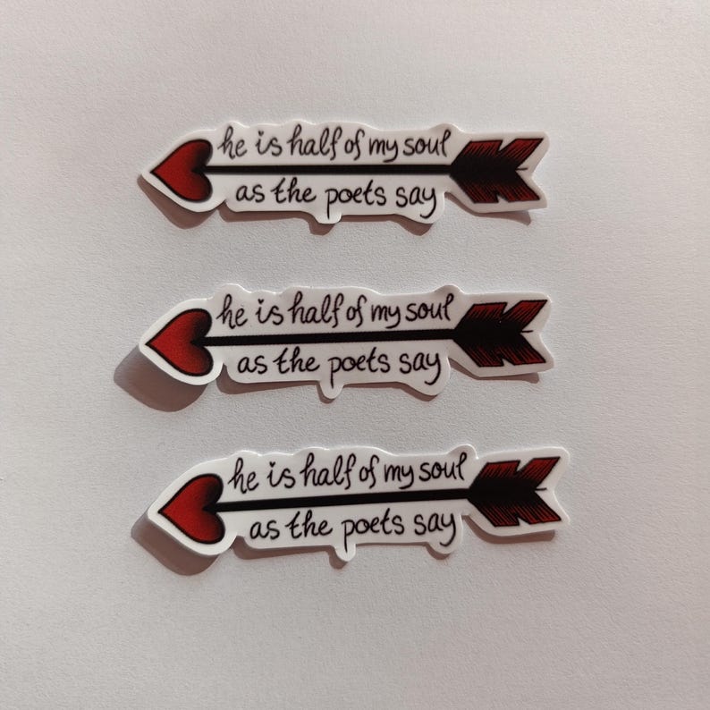 Peut inclure: Trois autocollants blancs avec des c&oelig;urs rouges et des fl&egrave;ches noires. Chaque autocollant porte le texte "he is half of my soul as the poets say" &eacute;crit en cursive noire.