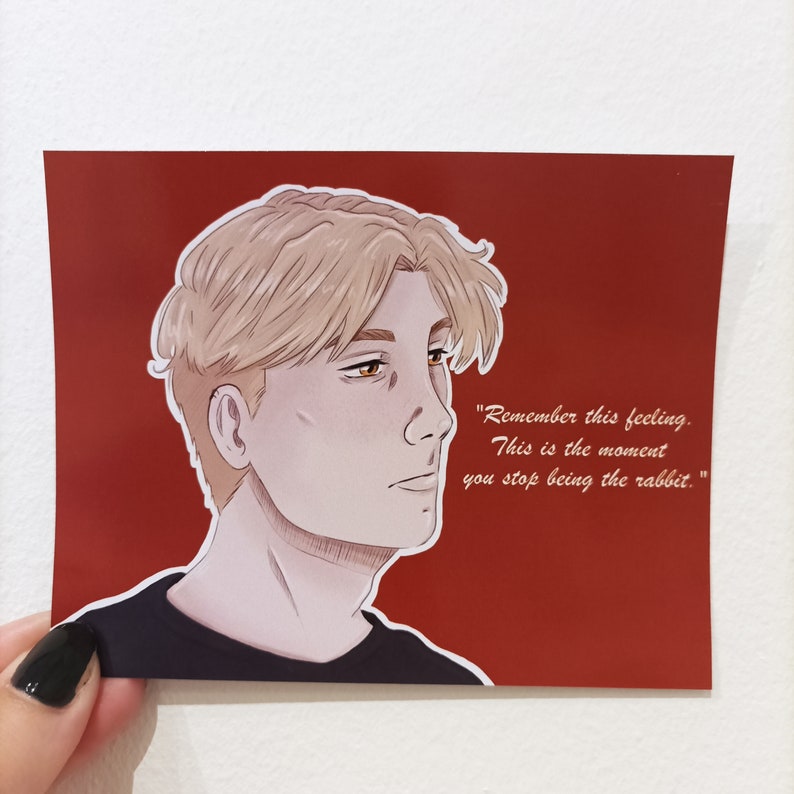 May include: A digital illustration of a young man with blond hair and a serious expression. He is wearing a black shirt and the background is red. The text "Remember this feeling. This is the moment you stop being the rabbit." is written in white on the right side of the image.