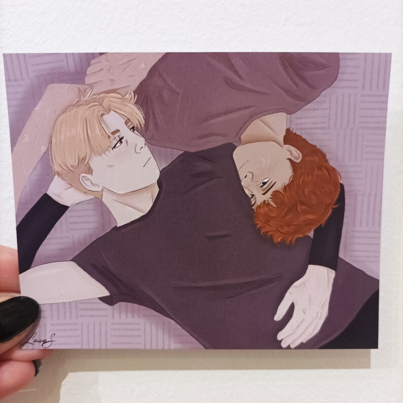 May include: Two people are lying on a patterned surface, one with blonde hair and a purple shirt, the other with red hair and a black shirt. They are facing each other and appear to be cuddling.