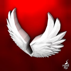 Puede incluir: Alas blancas de papel con un dise&ntilde;o geom&eacute;trico, dobladas en forma de coraz&oacute;n. Las alas est&aacute;n sobre un fondo rojo.