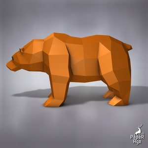 May include: A brown origami bear standing on a grey surface. The bear is made of paper and has a simple, geometric design.